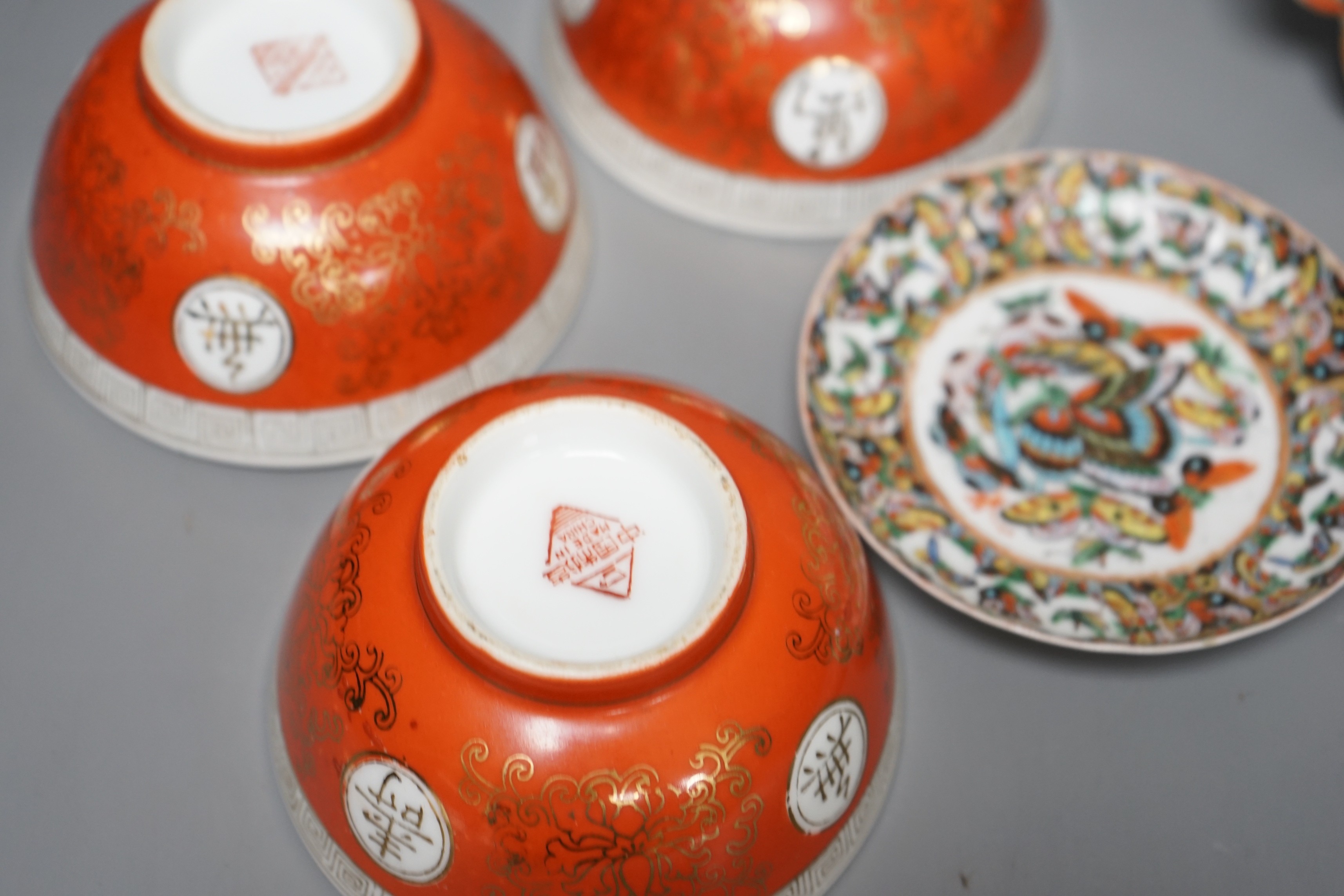 A Chinese 'thousand butterfly' dish and two saucers, early 20th century and three later Chinese coral round bowls, largest 20cm diameter